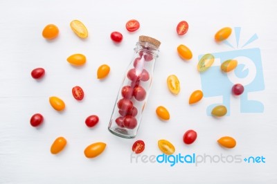 Red And Yellow Cherry Tomatoes On A White Background, Top View Stock Photo