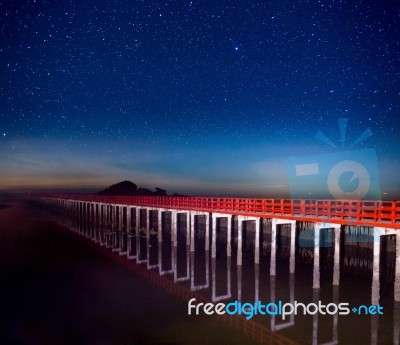 Red Bridge In The Night Sky With Star On Top Of The Sea Stock Photo