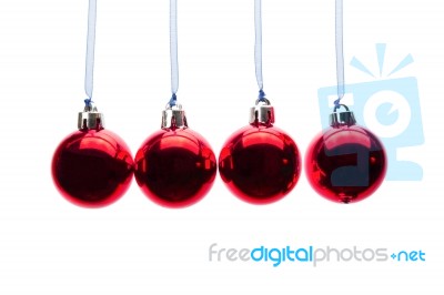 Red Christmas Balls Hanging In A Row On White Background Stock Photo