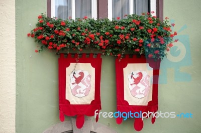 Red Geraniums And Flags On A House In Rothenburg Stock Photo