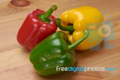 Red Green And Yellow Sweet Peppers On Table Stock Photo