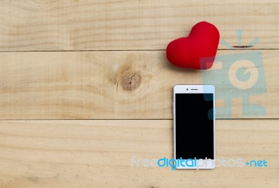 Red Heart And Smartphone On Wood Background Stock Photo