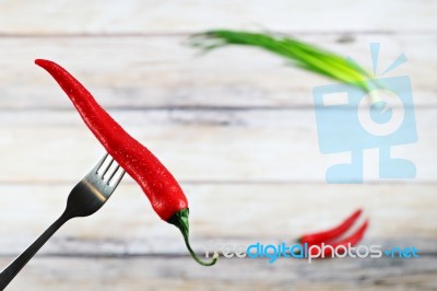 Red Hot Chili Pepper With Water Drops On Fork Stock Photo