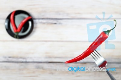 Red Hot Chili Pepper With Water Drops On Fork Stock Photo