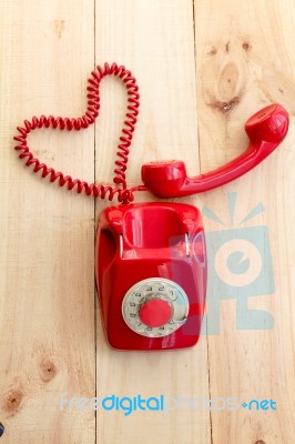 Red Landline Which Cable Has Heart Shape On Wooden Background Stock Photo