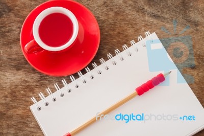 Red Mug With Open Notebook Stock Photo