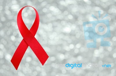 Red Ribbon Sign On Silver Bokeh Background Stock Photo