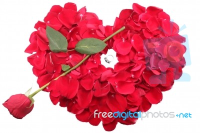 Red Rose Petals In Heart Shape With Rose Arrow And Diamond Ring Stock Photo