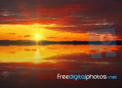 Red Sunset Sky Reflected In The Water Stock Photo