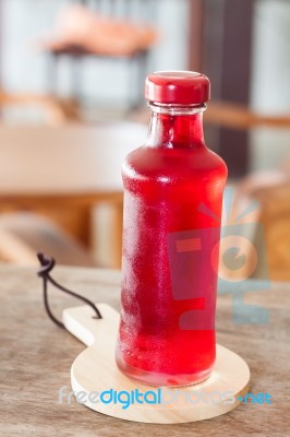 Red Syrup In The Bottle On Wooden Plate Stock Photo