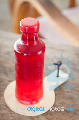 Red Syrup In The Bottle On Wooden Plate Stock Photo