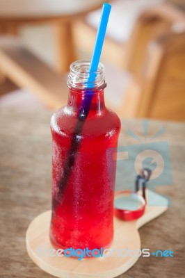 Red Syrup In The Bottle On Wooden Plate Stock Photo