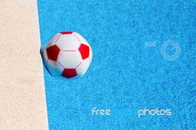 Red-white Beach Ball Floating  In Swimming Pool Stock Photo