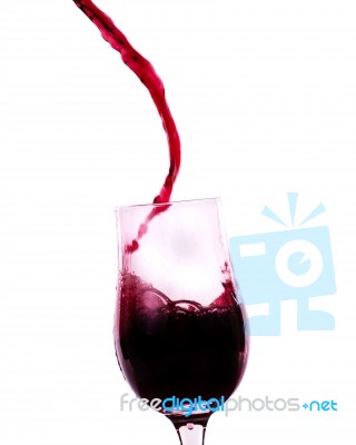 Red Wine Flowing Into The Glass Stock Photo