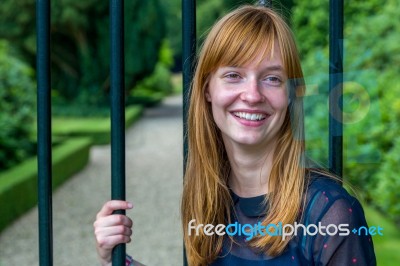 Redhead Girl Laughing Holding Bar Gate Stock Photo