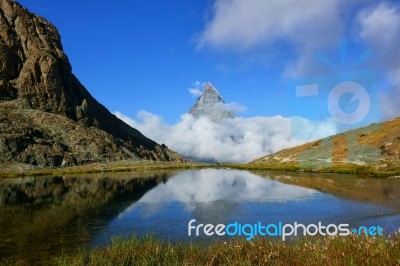 Reflection In The Riffelsee Of Matterhorn And Cloud Under With L… Stock Photo