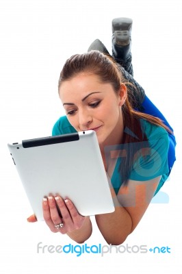 Relaxed Young Woman Surfing On Tablet Device Stock Photo