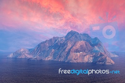 Rock Mountain Island In Ocean Under Dusk Sky Stock Image