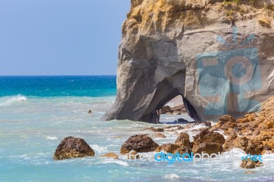 Rock With Cave In Sea At Greek Coast Stock Photo