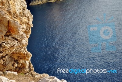 Rocky Coastline Overlooking A Blue Calm Sea Stock Photo