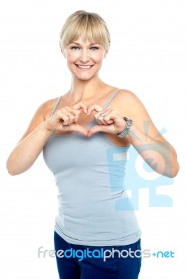 Romantic Middle Aged Woman Gesturing Heart Shape Stock Photo