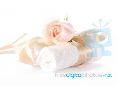 Rose With Decorative Ribbons Over Rolled Up Bath Towels Stock Photo