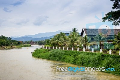 Row Of Tourist Bungalows Along Nam Song River In Vang Vieng, Vientiane Province, Laos. Vang Vieng Is A Popular Destination For Adventure Tourism In A Limestone Karst Landscape Stock Photo