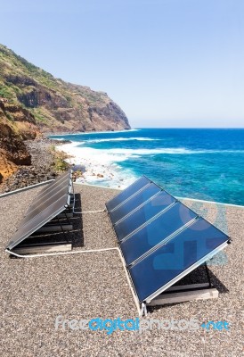 Rows Of Solar Collectors On Roof At Beach And Sea Stock Photo