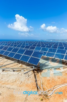 Rows Of Solar Panels Near Sea With Blue Sky Stock Photo