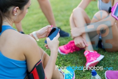 Running Girls Having Fun In The Park With Mobile Phone Stock Photo