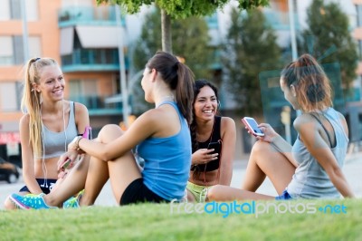 Running Girls Having Fun In The Park With Mobile Phone Stock Photo