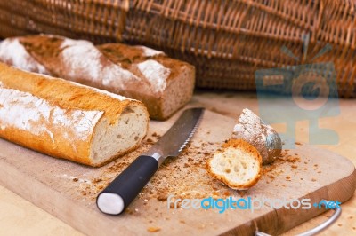 Rye And Wheat Bread Loafs And A Knife On Wooden Cutting Board Stock Photo