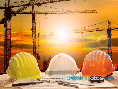 Safety Helmet On Engineer Working Table And Construction Site Stock Photo