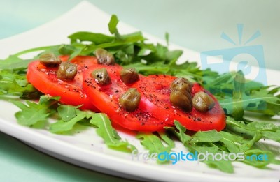 Salad With Fresh Tomatoes, Capers And Arugula Stock Photo