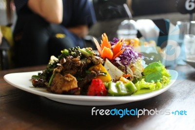 Salad With  Tomatoes, Yellow Bell Pepper On White Plate On Brown Table Background.  Salad For Healthy Food.  Stock Photo