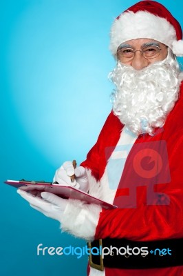 Santa Claus Making Notes In The Wish List Stock Photo