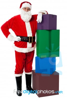 Santa Claus Posing Beside Pile Of Gifts On Christmas Eve Stock Photo