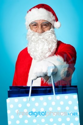 Santa Holding Shopping Bags In His Outstretched Arms Stock Photo