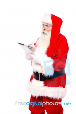 Santa Selecting Options While Surfing Stock Photo