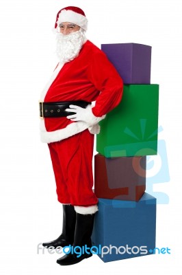 Santa Standing Beside Pile Of Xmas Gifts Stock Photo