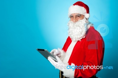 Santa Using Newly Launched Electronic Tablet Device Stock Photo