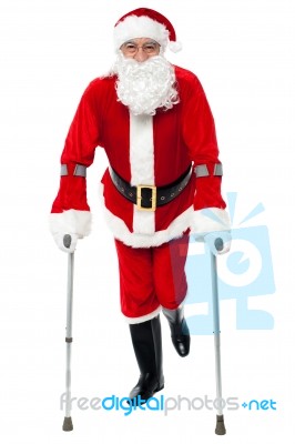 Santa Walking With The Help Of Crutches Stock Photo