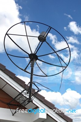 Satellite Dish Stuck To Roof Of House In Blue Sky Stock Photo