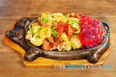 Sausage With Potatoes, Vegetables And Hot Sauce On A Plate Stock Photo