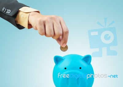 Saving Money, Hand Putting Coin Into Piggy Bank Stock Photo