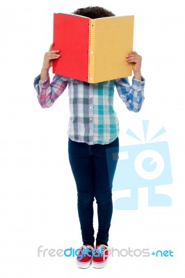 School Girl Hiding Her Face With A Book Stock Photo