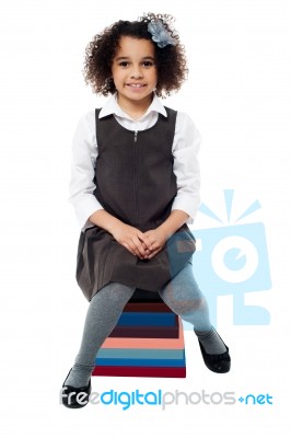 School Girl Sitting On Pile Of Books Stock Photo