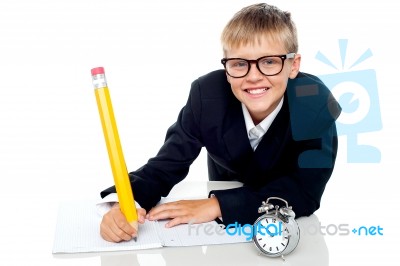 Schoolboy Writing With Timepiece Stock Photo