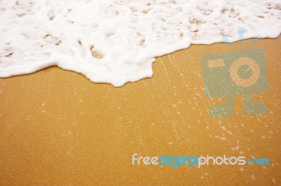 Sea Wave With Foam On Sand Stock Photo