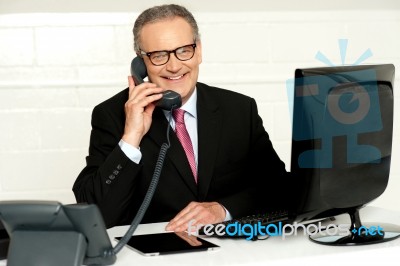 Senior Businessman Attending Phone Call Stock Photo